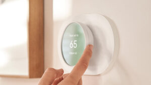 a picture of a hand adjusting a thermostat